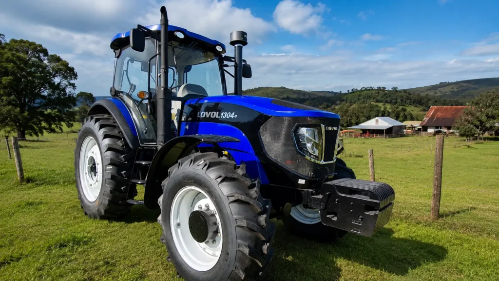 Tractor agrícola con doble tracción trabajando en pradera húmeda en el sur de Chile durante el invierno